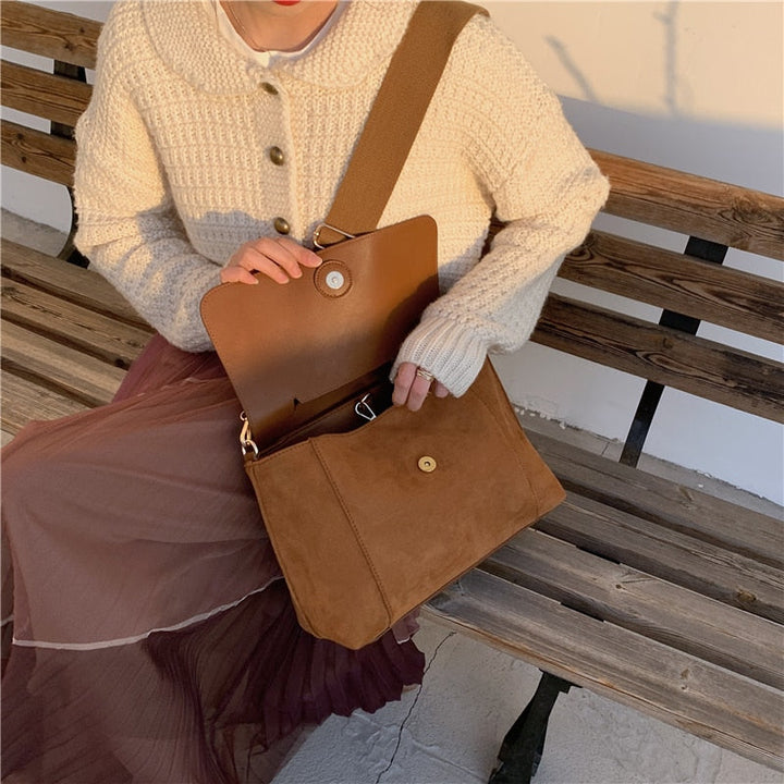 Dam bär brun crossbodyväska. Praktisk vardagsväska som modeaccessoar, elegant passform för en kvinnlig stil.