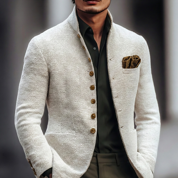 Man iklädd vit texturerad cardigan med stående krage och mörk skjorta