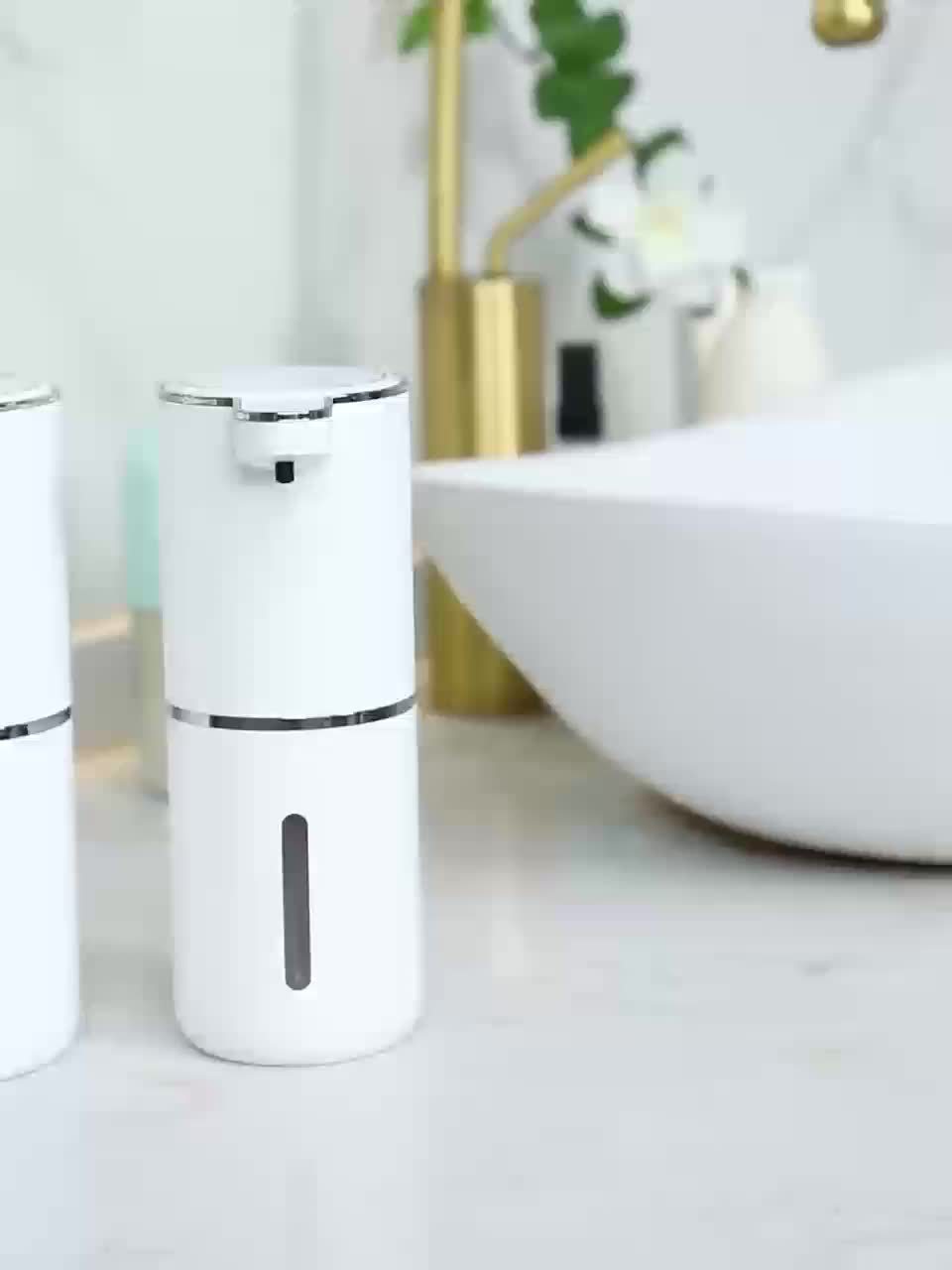 Vit automatisk tvåldispenser placerad i ett modernt badrum
