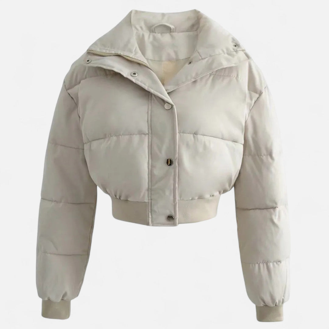 Beige damjacka på galge som visar den lösa passformen och fickor