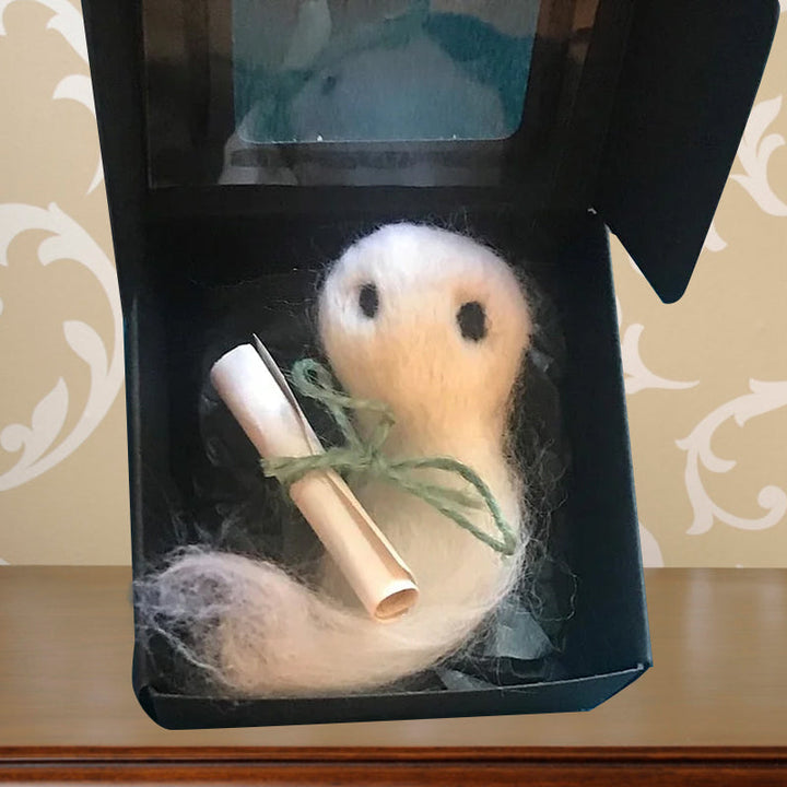 "Charmig handgjord filttom med unika detaljer, perfekt för Halloweendekoration, vilande i svart silkespapper."
