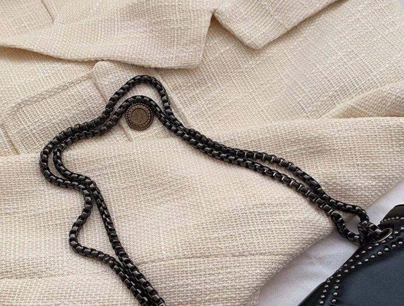 Snygg svart damväska: crossbody, nitar, kedja. Kompakt lyxig axelremsväska för trendiga kvinnor.