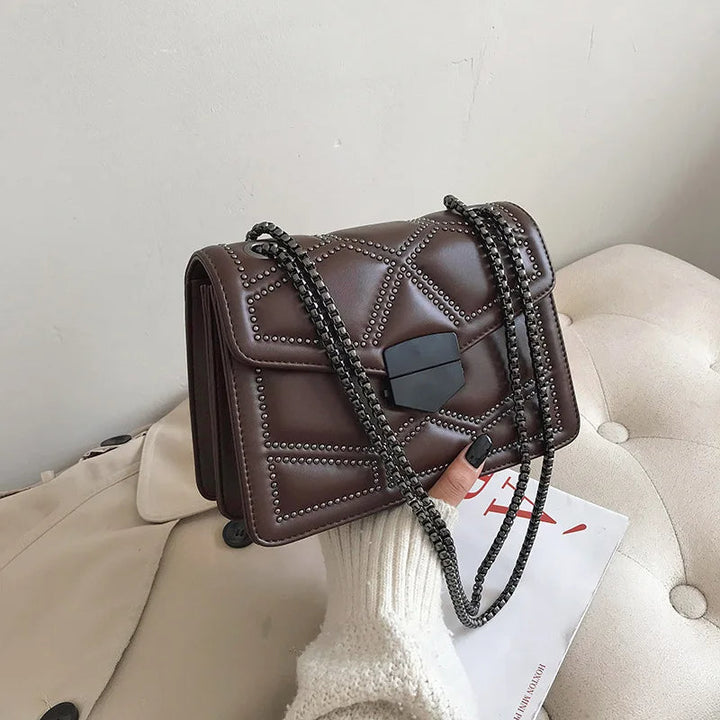 Elegant nitad damväska med metallkedja. Svart crossbodyväska, kompakt & lyxig accessoar.