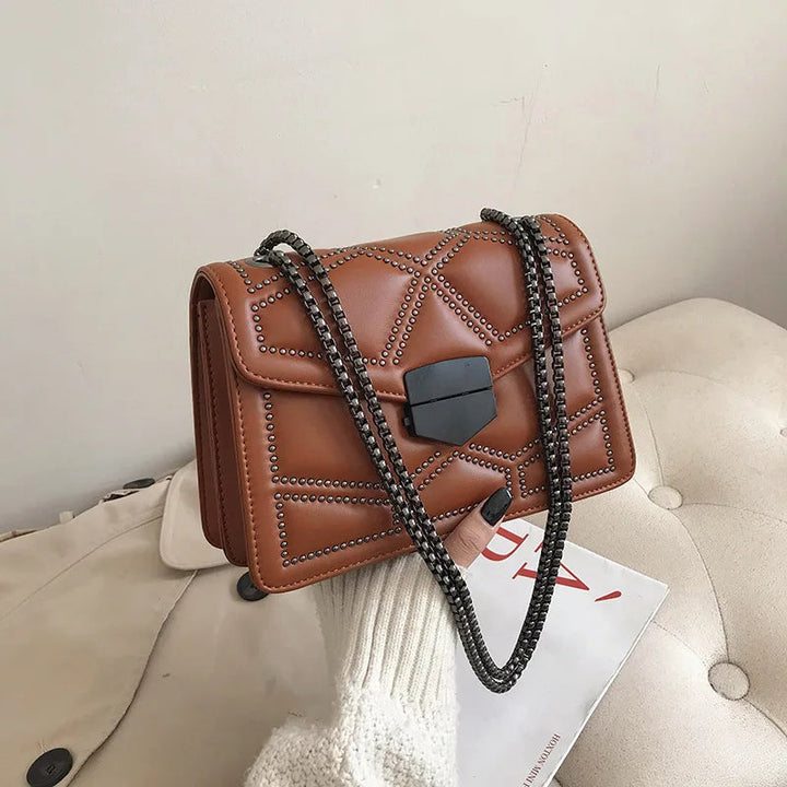 Svart lyxig crossbodyväska för dam. Handväska med nitar och kedja, perfekt för accessoarer.