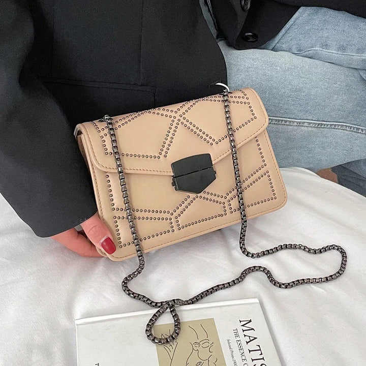 Brun nitad crossbodyväska för dam med elegant kedja. Kompakt och stilren axelremsväska.