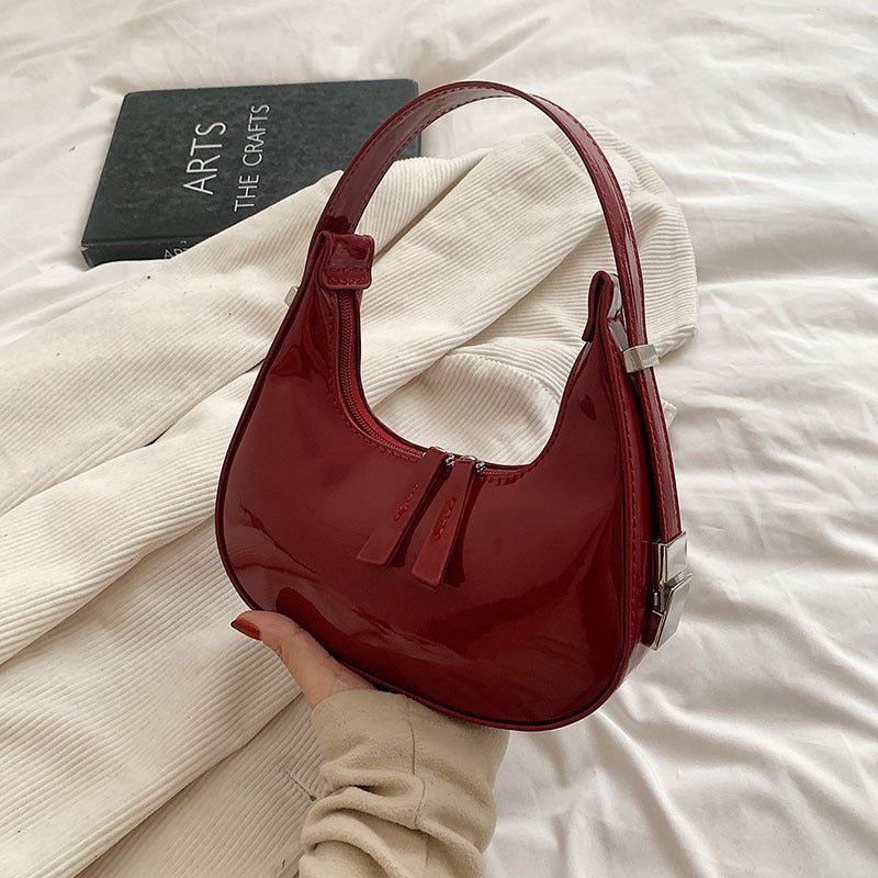 Röd Classic Elite elegant handväska i lackad stil som hålls i handen