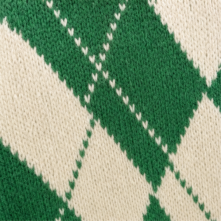 Detaljbild på mönster och stickning för argyle poncho