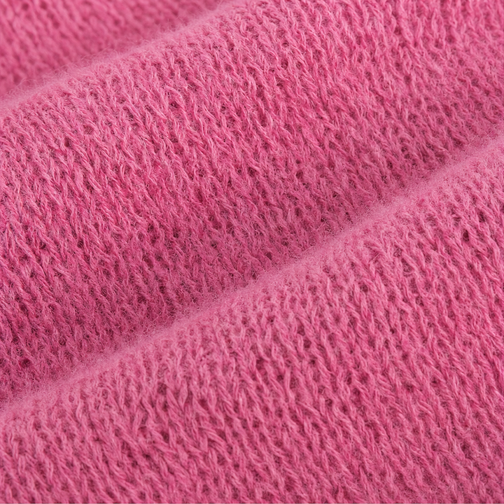 Detaljbild på rosa garn och öppen stickning i tröja med huva