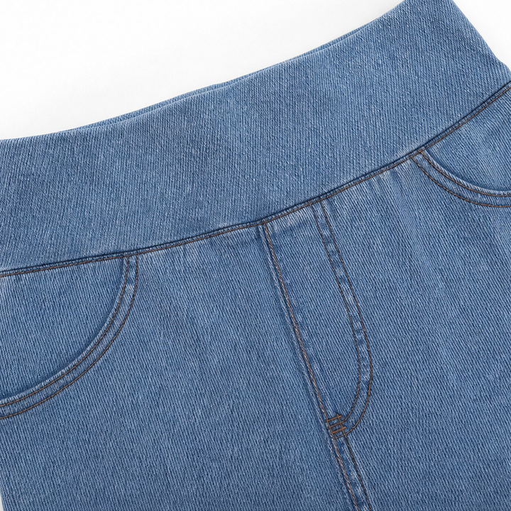 Detaljbild på tyg och struktur i stretchig denim för dam