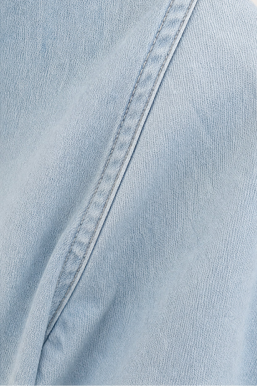 Närbild på tyg och krage på blå damskjorta i chambray