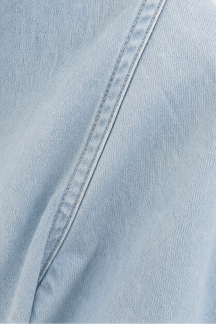 Närbild på tyg och krage på blå damskjorta i chambray
