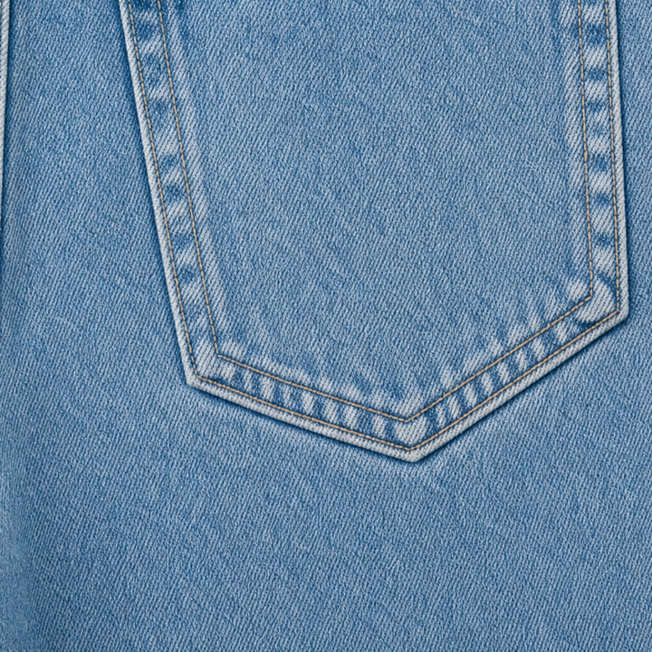 Detaljbild på ficka och sömmar på damjeans i ljusblå denim