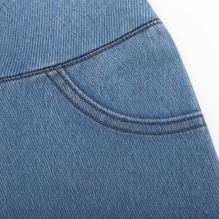 Närbild på knappdetalj och midja på grå damjeans