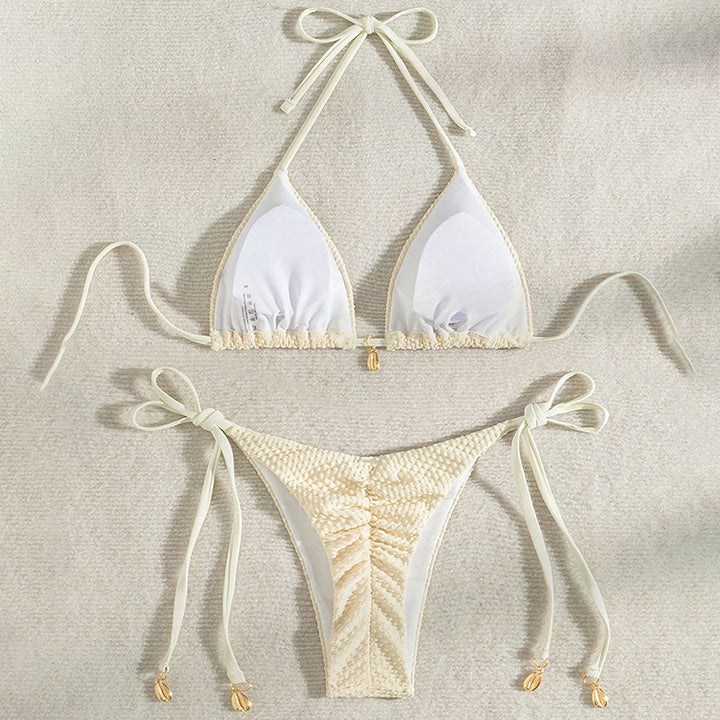 Närbild av strukturerad yta på crème triangelbikini, visar tygets textur & de justerbara banden.