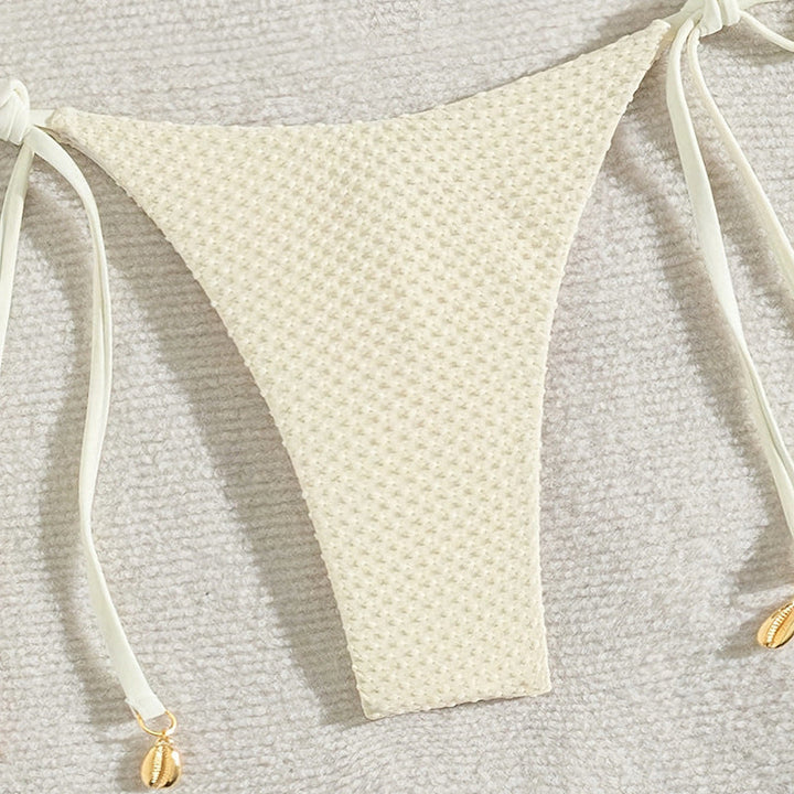Modern crème triangelbikini med unik strukturerad yta. Komfortabla badkläder för en avslappnad sommarstil.