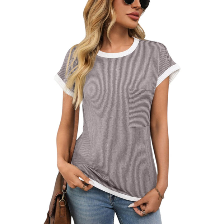 Modell bär en stilren dam t-shirt med rund hals, kort ärm och bröstficka, perfekt för casual stil.