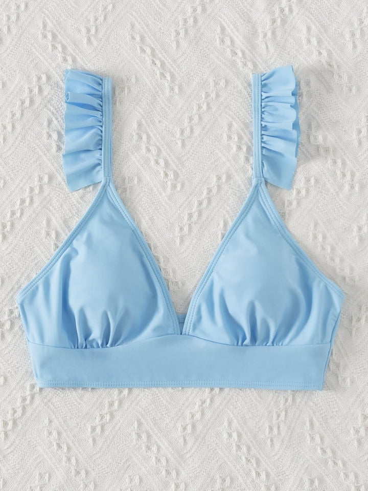 Stilren dam badtopp i triangelmodell. Volangdetaljer ger en feminin touch. För strand och pool.