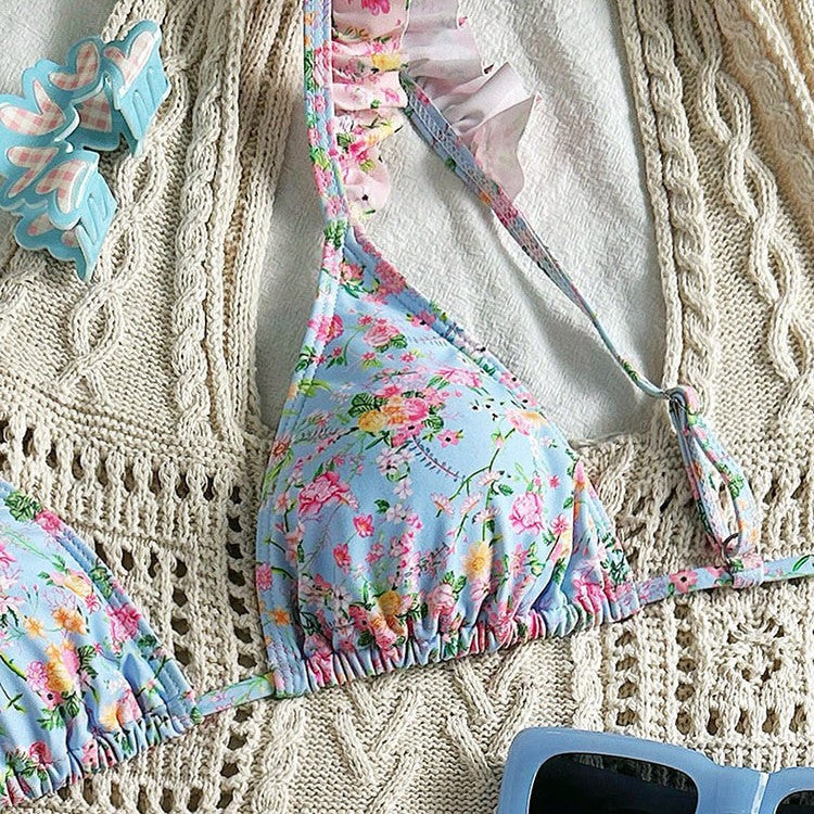 Blommig triangelbikini för dam med eleganta volanger och justerbara axelband. Perfekt badkläder för sommaren.