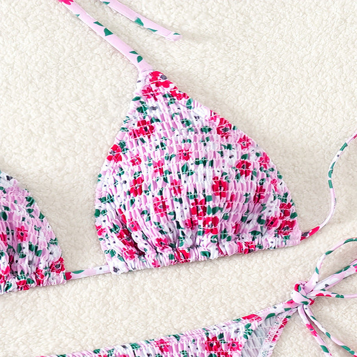 Elegant dambikini med blommönster, triangeltopp och rynkade sidor, för en chic look vid poolen.
