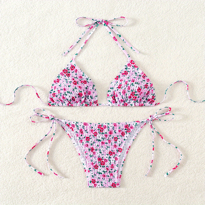 Vibrerande blommig triangelbikini med rynkade detaljer, perfekt badmode för soliga dagar vid stranden.