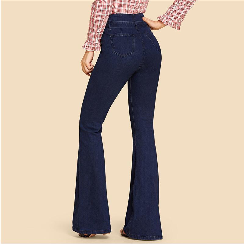 Dambyxor i blå denim med hög midja och vida ben, som visas med avtagbart bälte för justerbar passform, vilket ger en elegant och tidlös look.