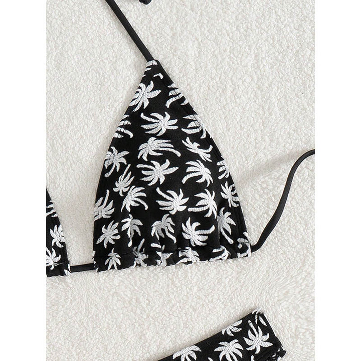 Trendig dambikini med palmmönster, triangeltop och högbenskuren trosa för en elegant look på stranden.