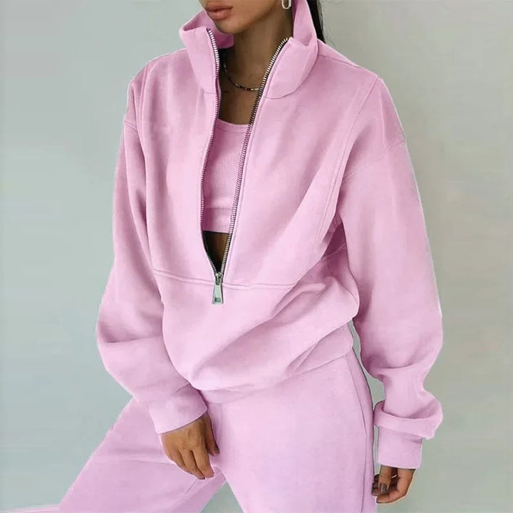 Kvinnligt loungewear-set med tröja och byxor, vid passform och halvdragkedja för maximal komfort.