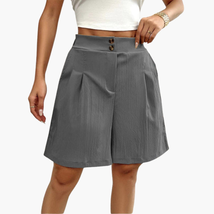 Damshorts med hög midja, dekorativa knappar och praktiska sidofickor. Eleganta sommarshorts för dam.