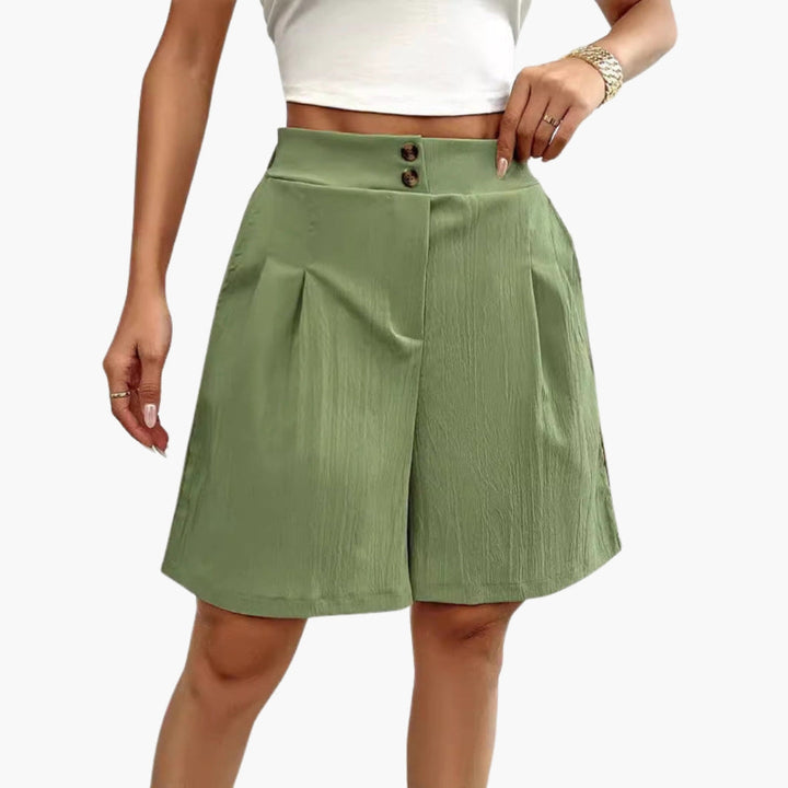Detaljbild av damshorts med fokus på dekorativa knappar, hög midja och sidofickor. Eleganta shorts.
