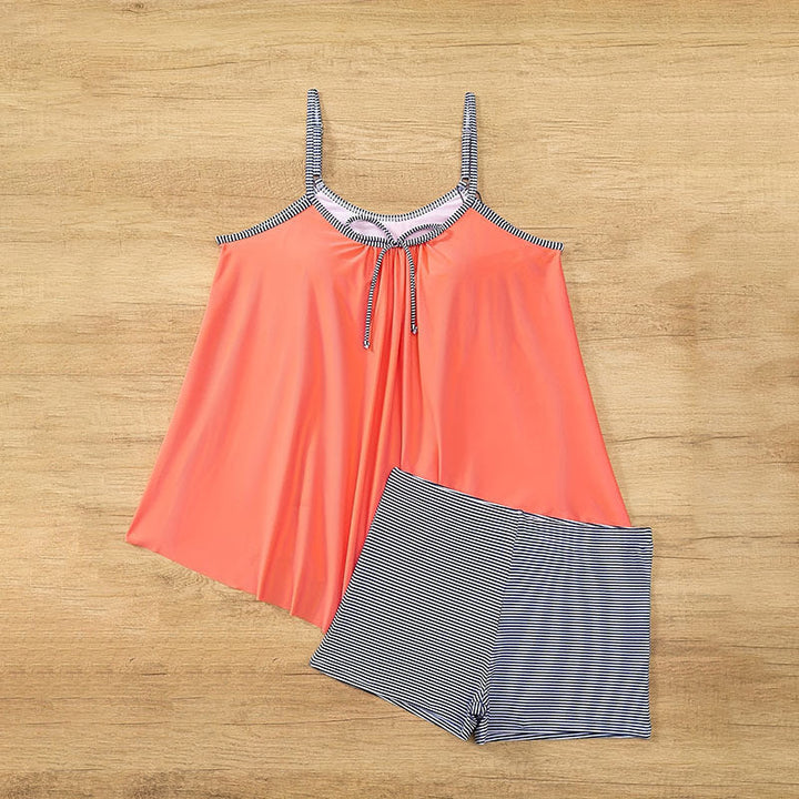 Stilrent tankini-set för dam. Asymmetrisk topp och högmidjade randiga shorts, idealiskt för soliga dagar.