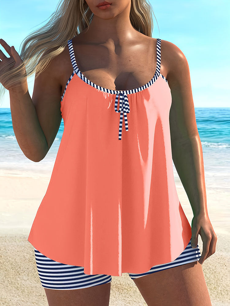 Modernt tankini-set för dam med unik asymmetrisk design och trendiga randiga högmidjade shorts.