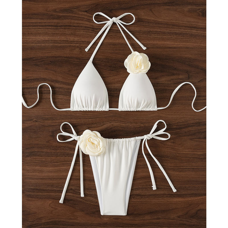 Elegant damtriangelbikini med blommiga applikationer och justerbara knytband, redo för sol och bad.