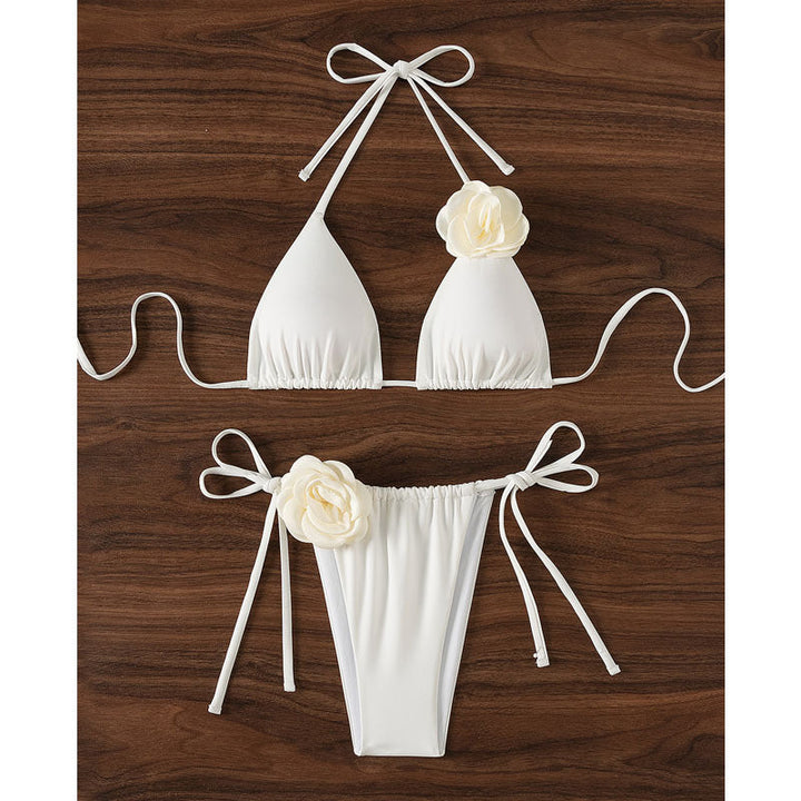 Elegant damtriangelbikini med blommiga applikationer och justerbara knytband, redo för sol och bad.