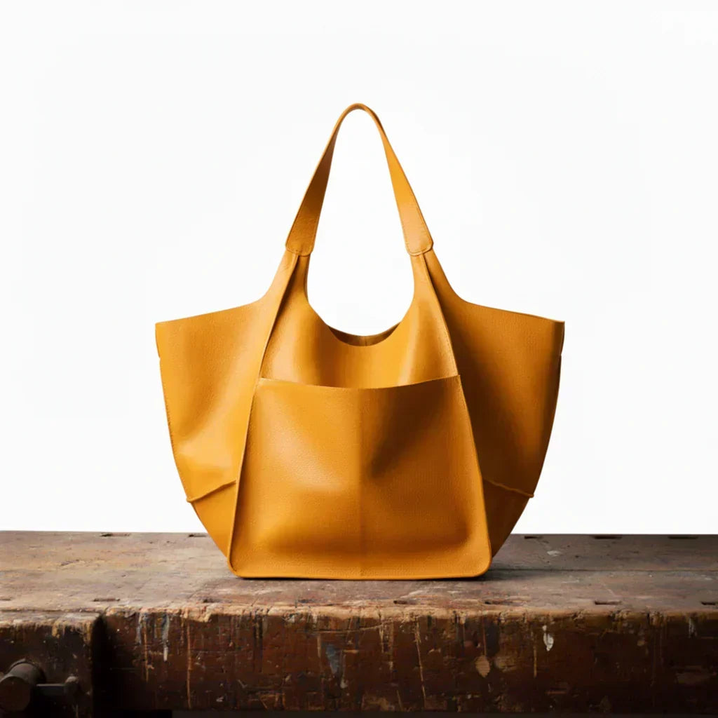 Gul tote-väska i klassisk design stående på träbord