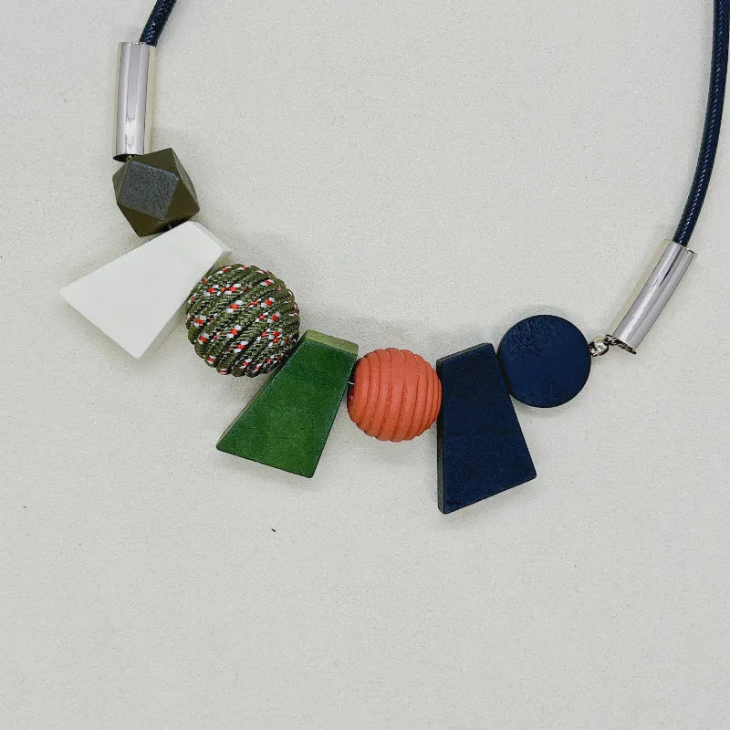 Närbild på textur av naturliga träpärlor i detta handgjorda geometriska halsband.
