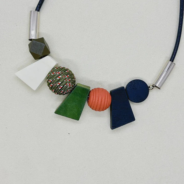 Närbild på textur av naturliga träpärlor i detta handgjorda geometriska halsband.