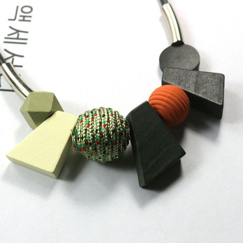 Geometriskt damhalsband med träpärlor i vintageinspirerad stil, en tidlös accessoar.