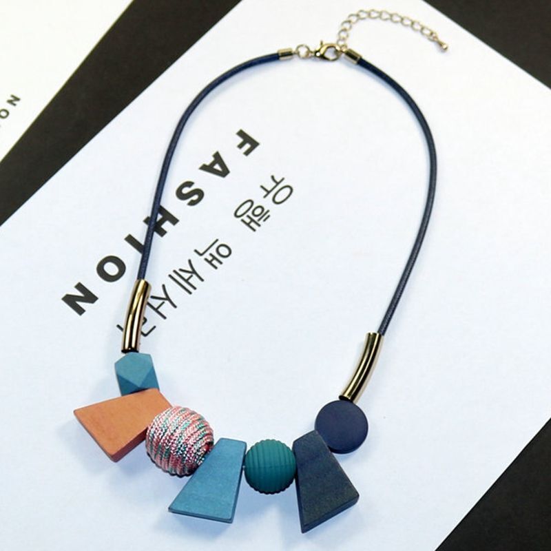 Långt, handgjort halsband med distinkta geometriska träpärlor, perfekt för lager på lager.