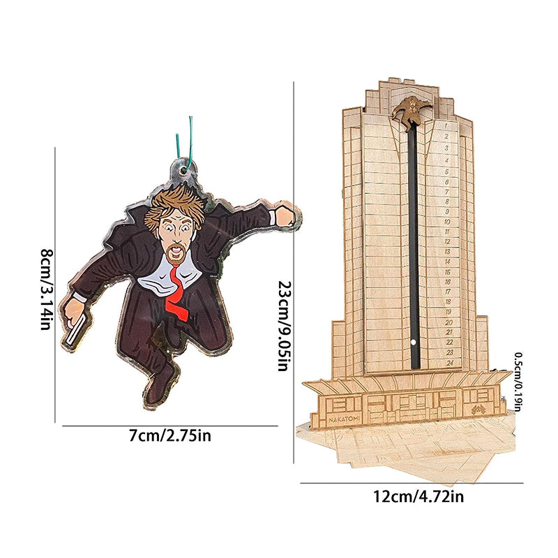 "Detaljerad trä Adventskalender med Die Hard-motiv, visar Hans Gruber faller från brunblå Nakatomi Plaza, roterbar design."