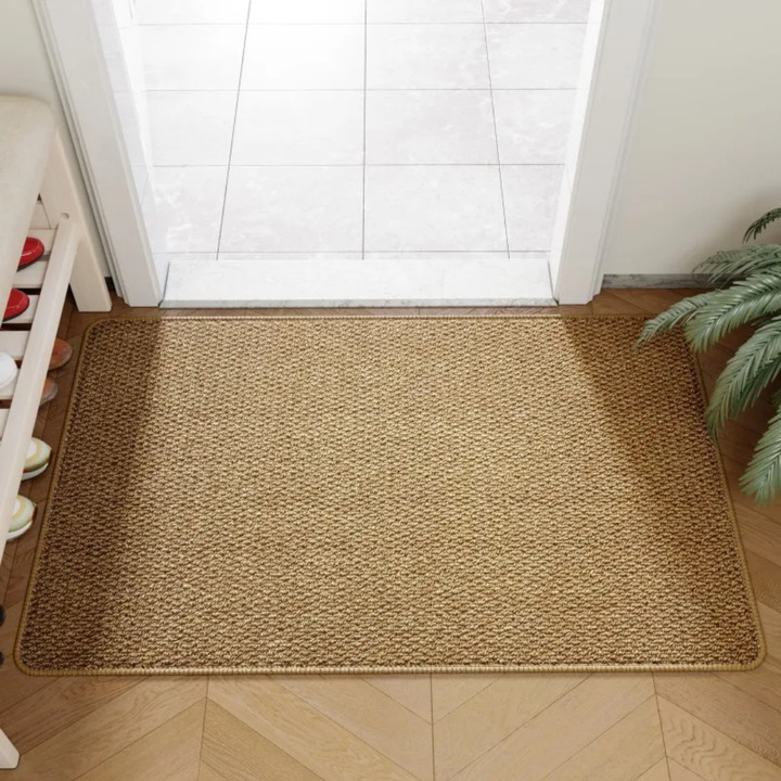 Brun dörrmatta med naturlig jute-look placerad i en ljus hall framför dörren.