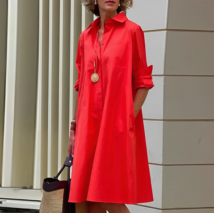 Kvinna i röd klassisk elegant skjortklänning utomhus