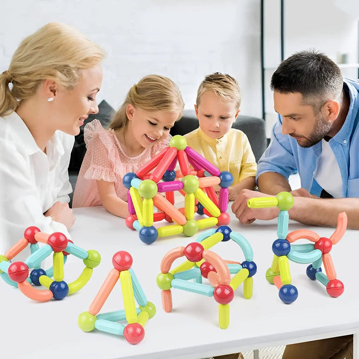 Familj som leker med färgglada magnetiska byggblock tillsammans