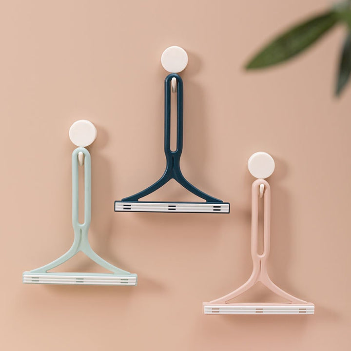 "Dubbelsidig manuell hårborttagningsapparat för kläder med ergonomiskt Y-handtag, silikonborste, grön, blå och rosa."