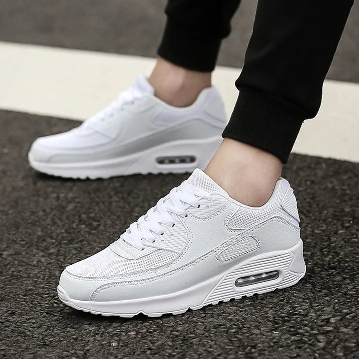 Man som bär vita sneakers utomhus på asfalt