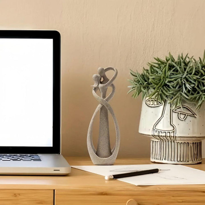 Abstrakt skulptur placerad på skrivbord bredvid bärbar dator