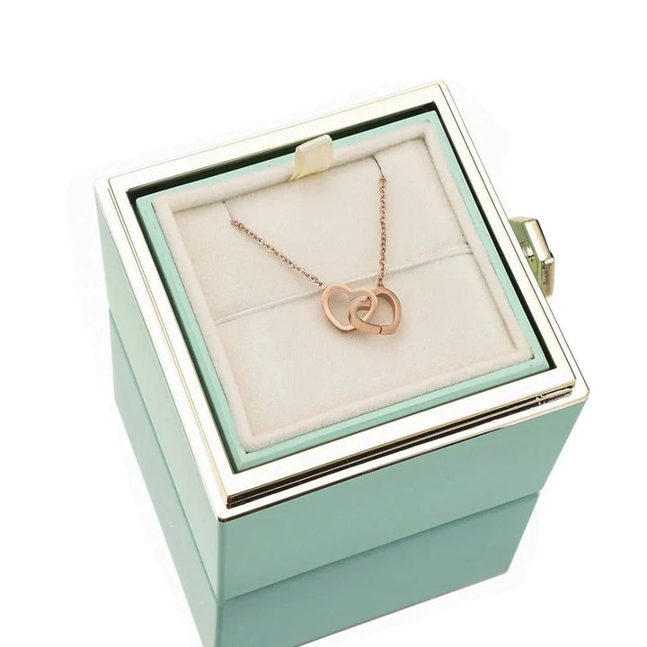 Öppen presentbox som visar både evig ros och halsband