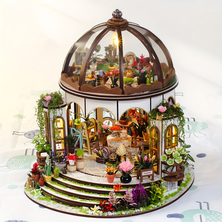 Översiktsbild av det upplysta miniatyrblomhuset i trä