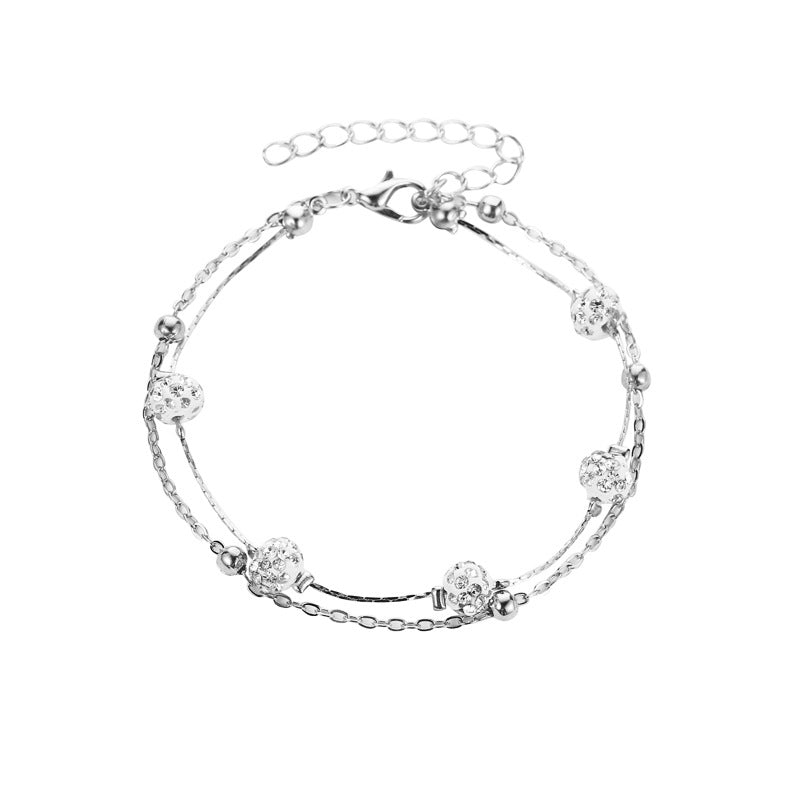 Elegant ankelband för damer med dubbla kedjor i guld och silver, prydd med klocka och zirkonkristaller.