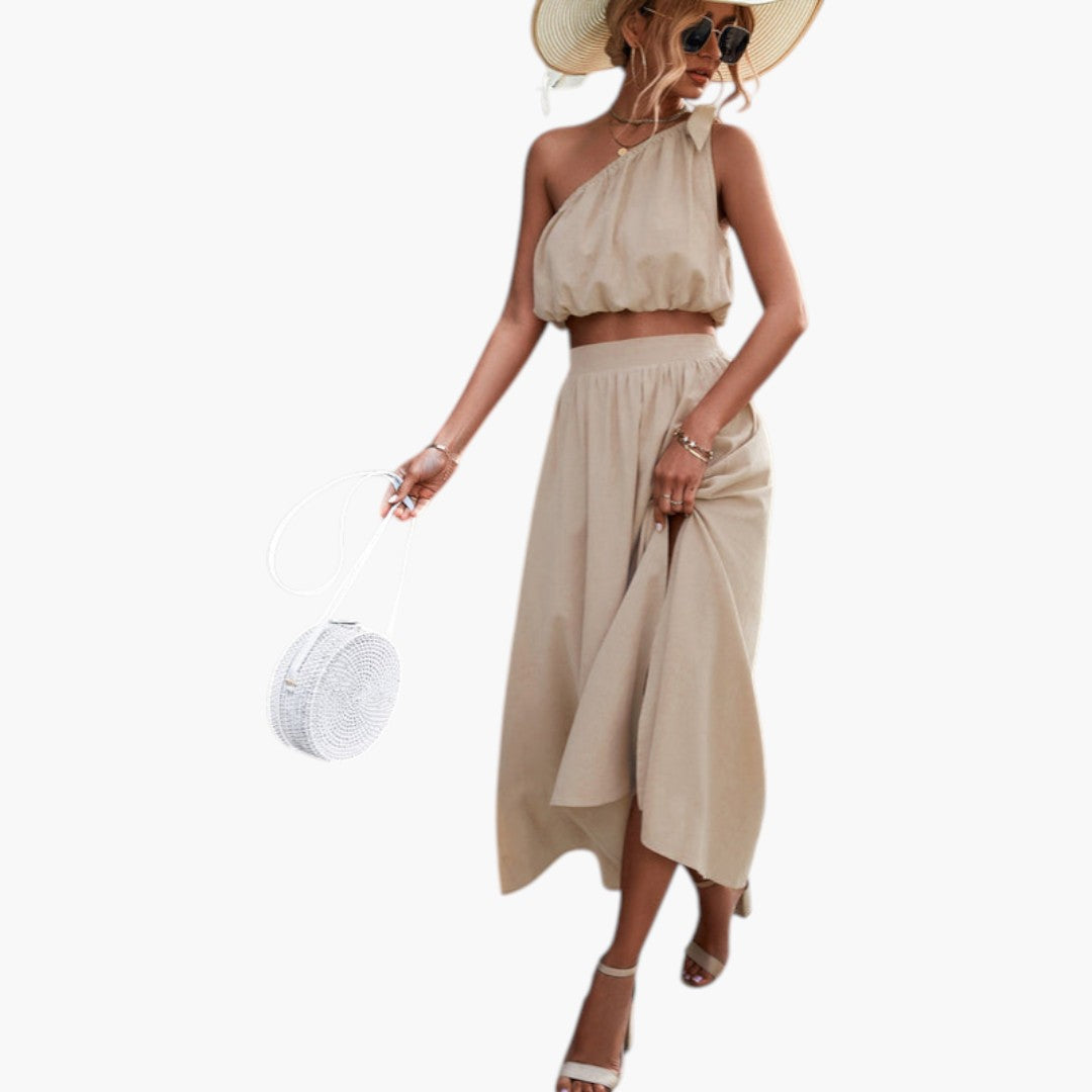 Snyggt aprikos kvinnors set: trendig enaxlad topp och bekväm midi kjol. Idealisk sommaroutfit och mode.