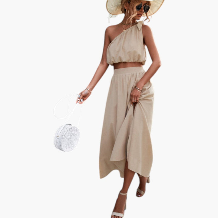 Snyggt aprikos kvinnors set: trendig enaxlad topp och bekväm midi kjol. Idealisk sommaroutfit och mode.